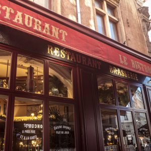 LYON, FRANCE - JULY 13, 2019: Traditional French Restaurant in Lyon, called Bouchon Lyonnais. It is a symbol of the Gatronomy of the second biggest French city

Picture of a Bouchon restaurant with a focus on its entrance. A bouchon is a type of restaurant found in Lyon, France, that serves traditional Lyonnaise cuisine